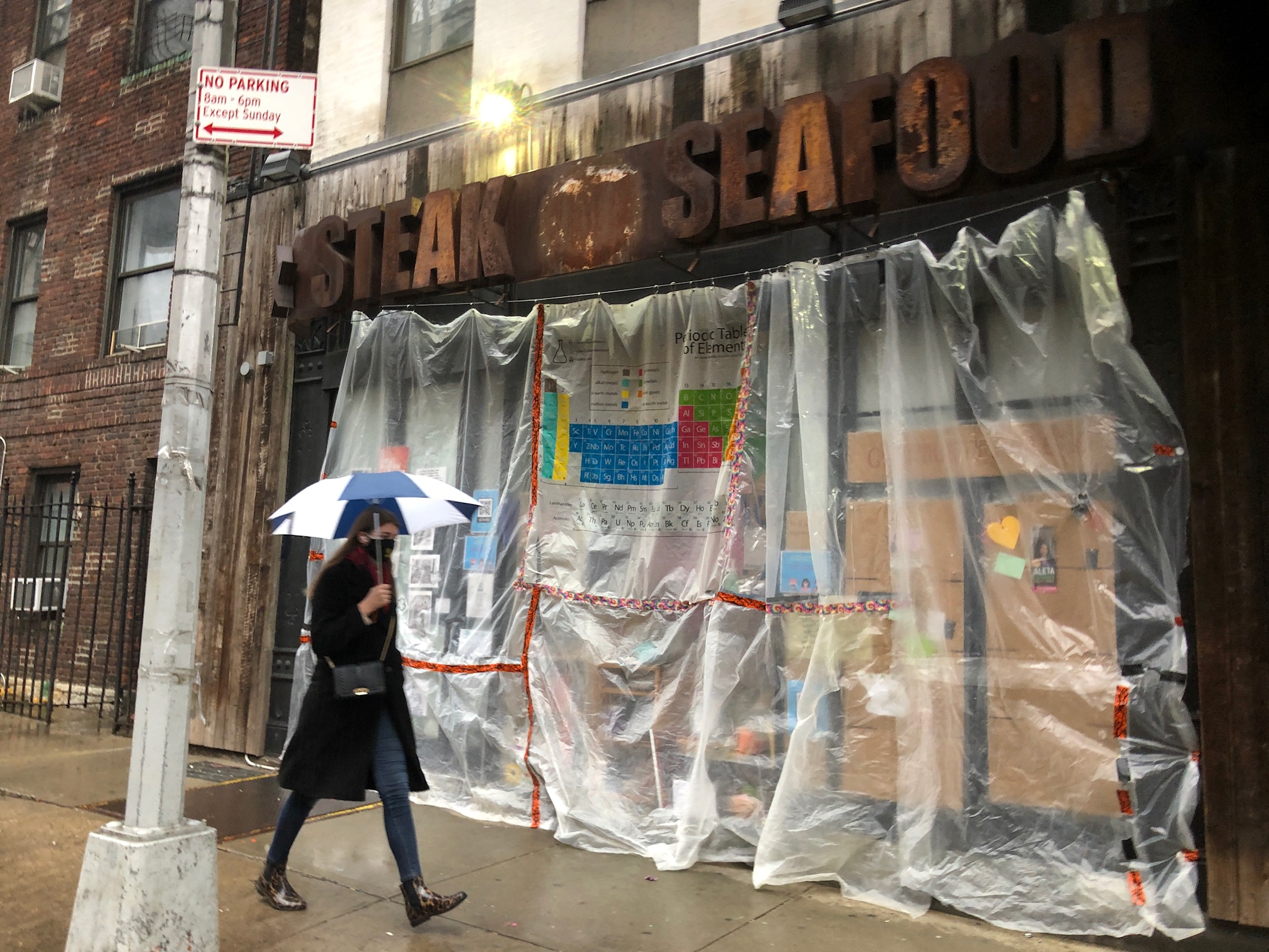 The Hell's Kitchen Free store on a rainy day with plastic covering the store front