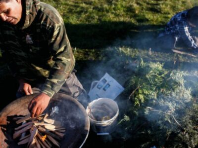 A Wiyot man tends a fire in preparation of the candlelight vigil remembrance ceremony.