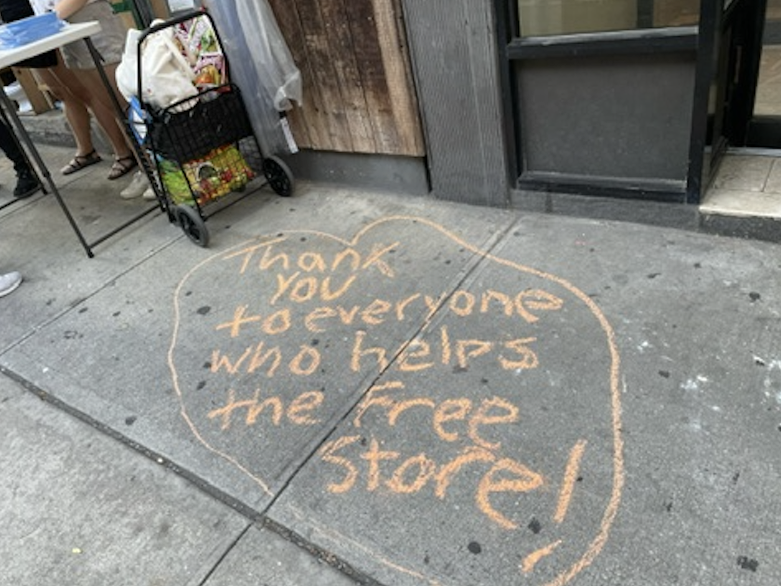 Chalk on the sidewalk reading, "Thank you to everyone who helps the free store!"